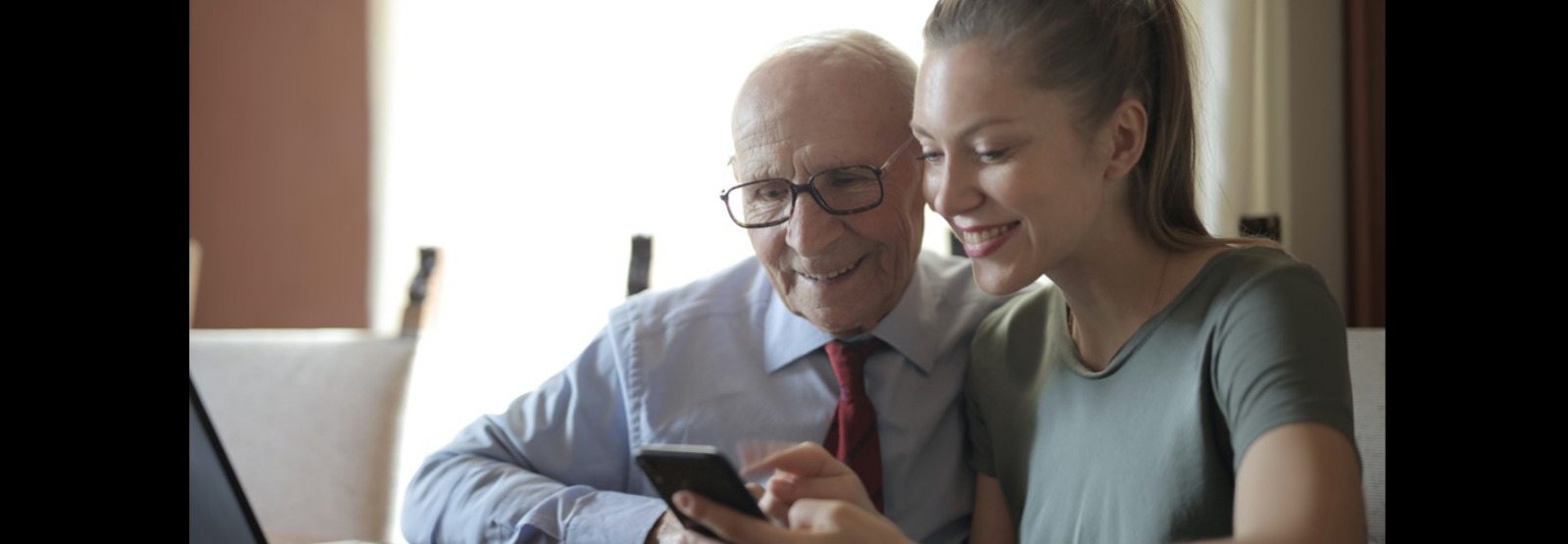 young woman and older man using cell phone
