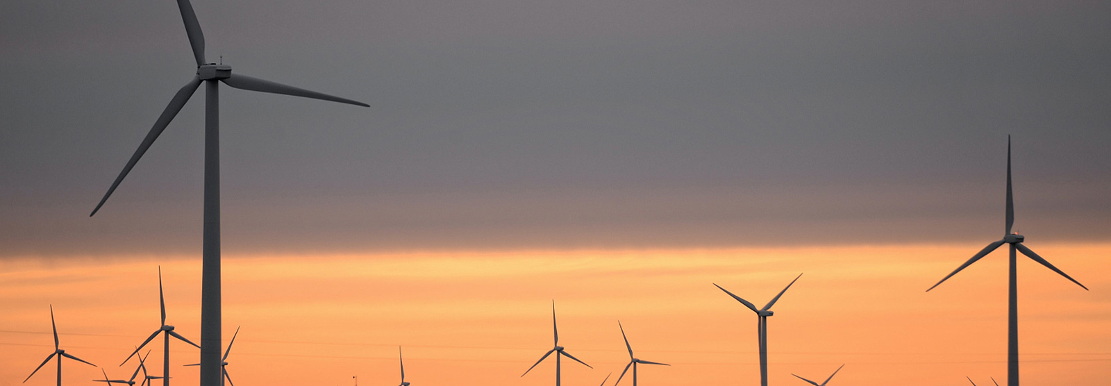 Wind turbines against sunset